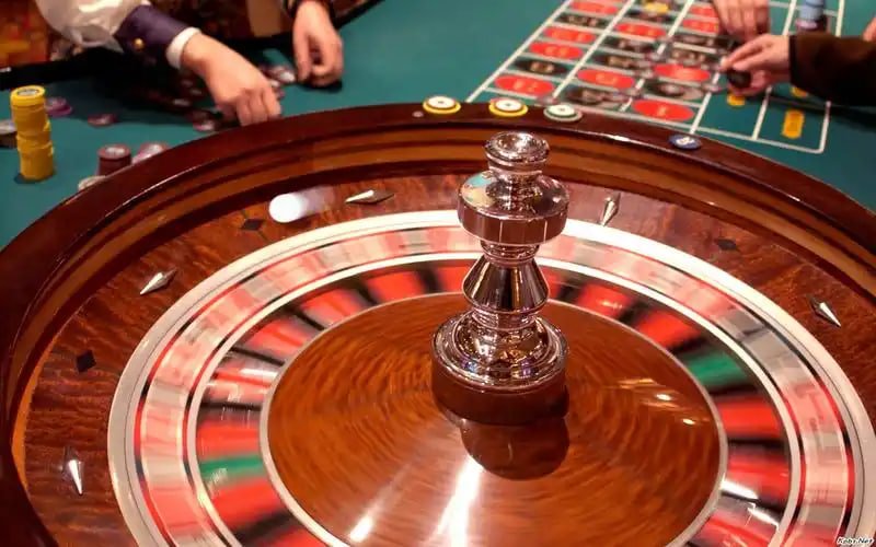 wosbet တိုက်ရိုက် ကာစီနို Baccarat table ပေါ်တွင် dealer ကဒ်ချနေသောပုံ